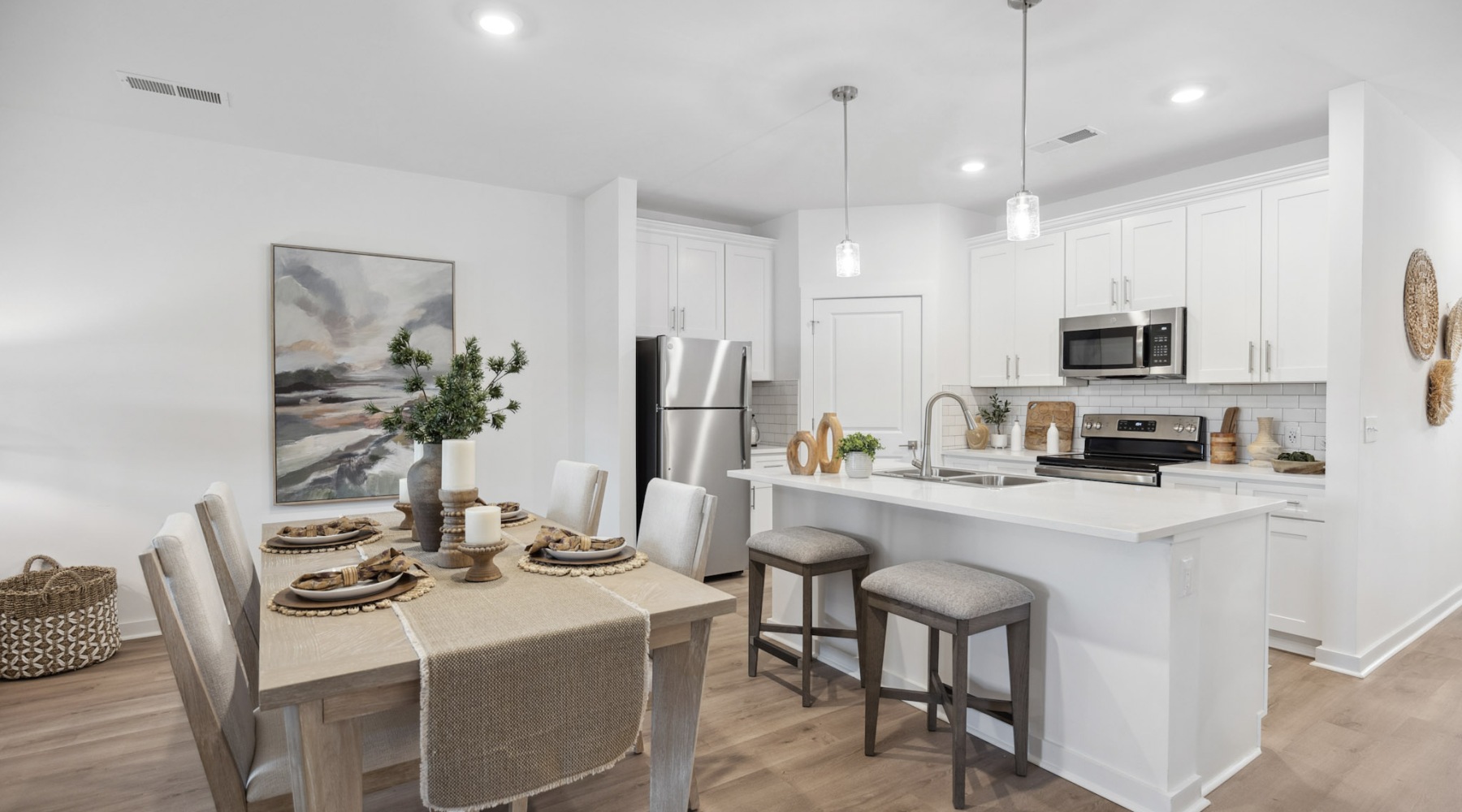 Model kitchen at our 55 and older community in Cornelius, NC, featuring wood grain flooring and a kitchen island.