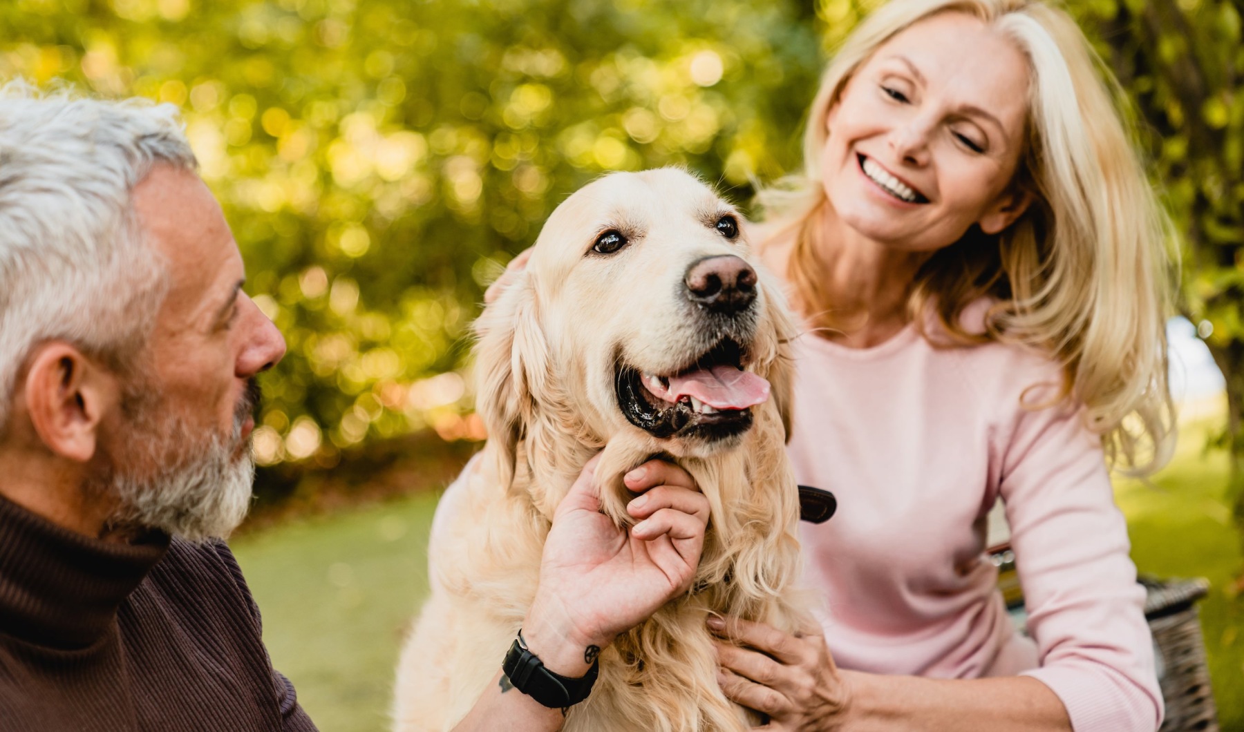 a man and a woman holding a dog