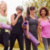 People laughing and standing outside with yoga mats near our 55 and older community in Cornelius, NC.