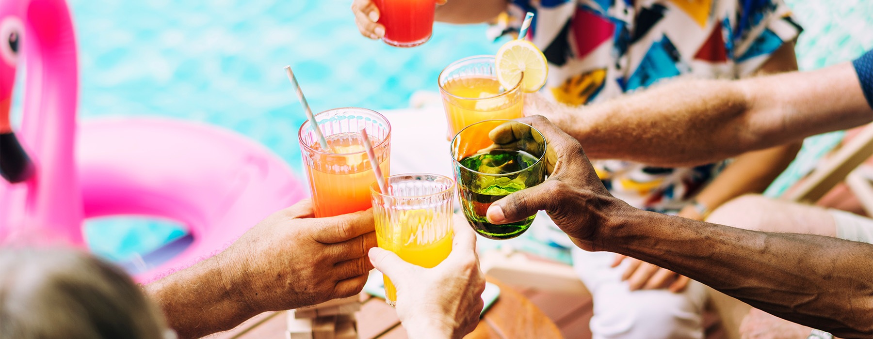 people at a pool raising drinks