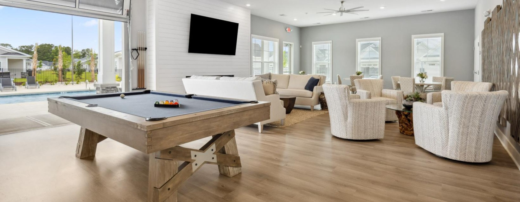 a large living room with a pool table and chairs