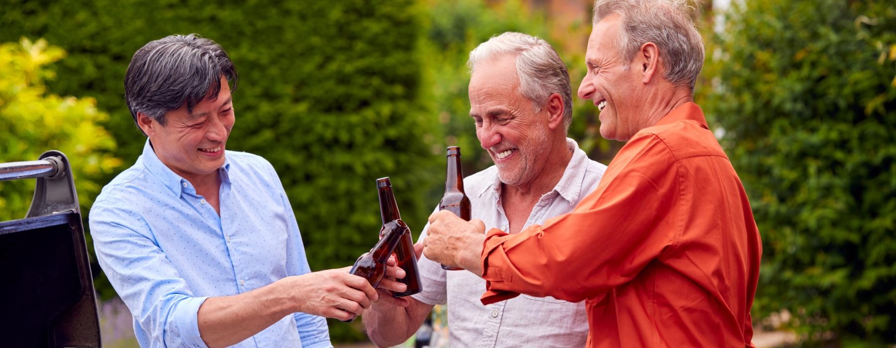 a few men holding bottles of beer